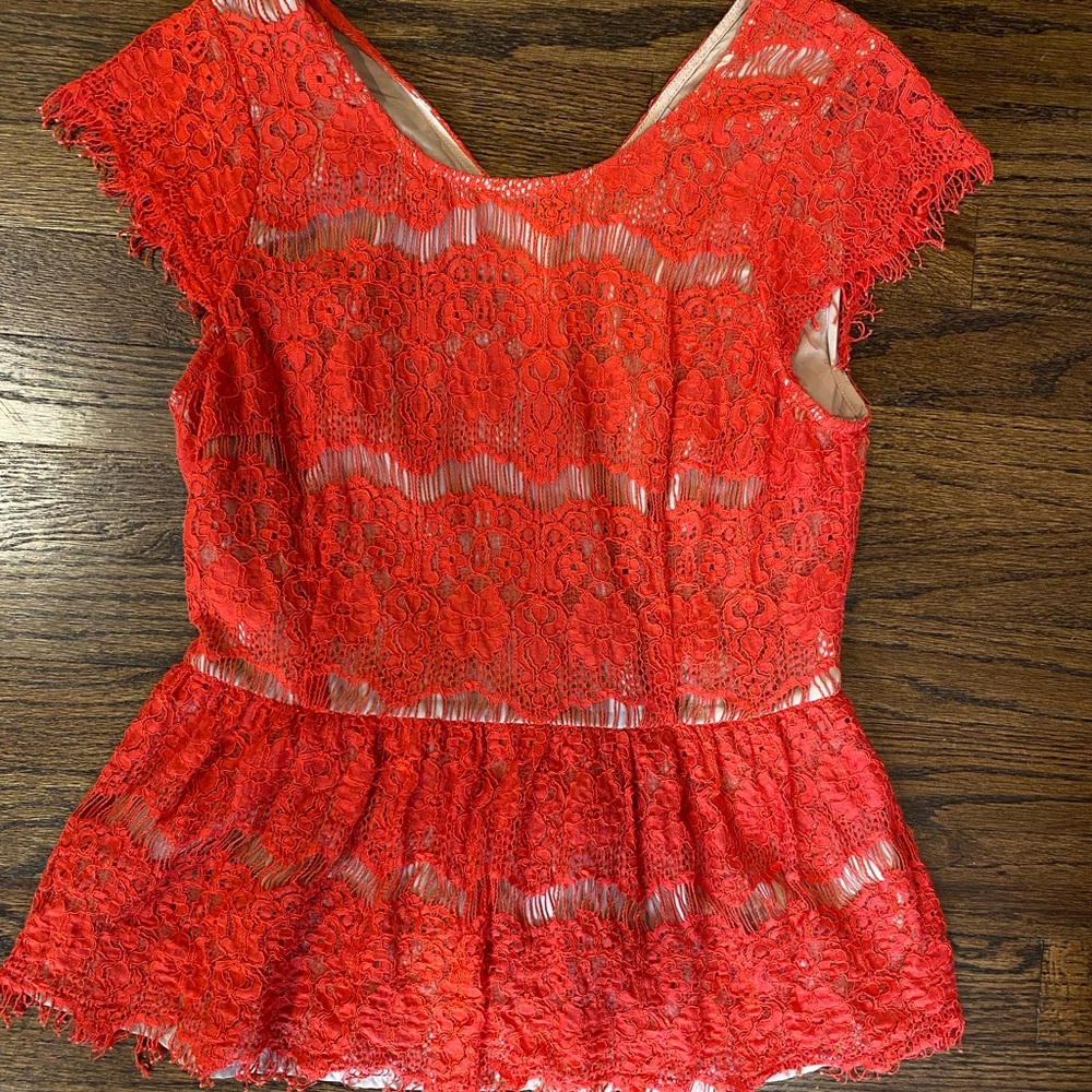 Salmon colored blouse with nude sheer underneath.